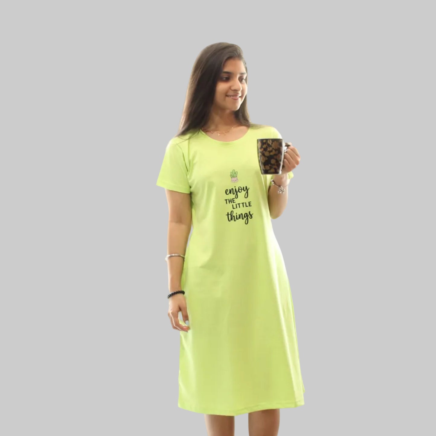women wearing a parrot green color cotton knee length short nighty, holding a mug