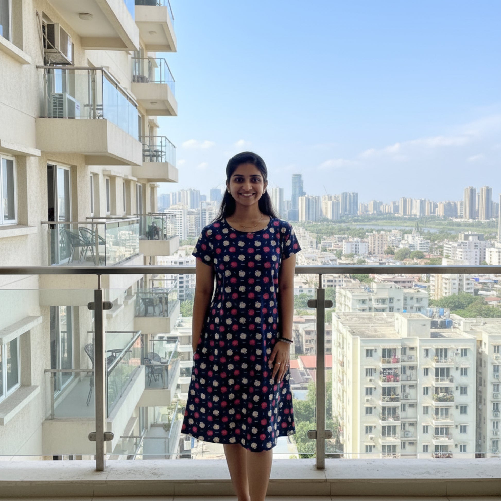 women wearing cotton knee length short nighty in navy color with floral design printed all over, hands in pocket