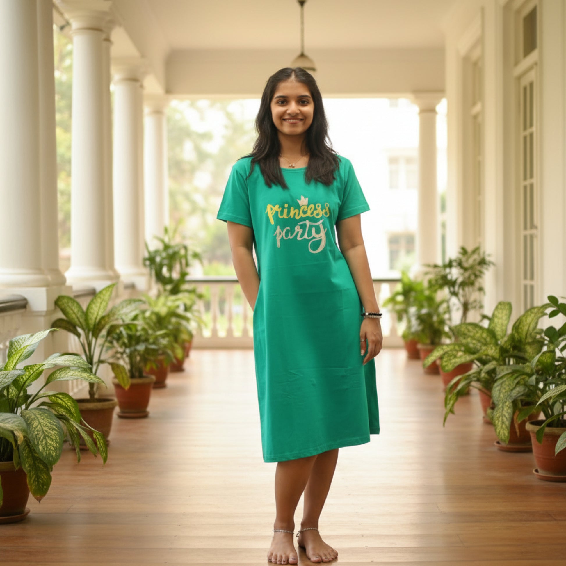 women wearing rama green color cotton short nighty with pocket, text princess party printed on the chest area, knee length dress 
