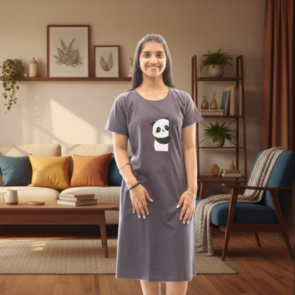 Woman wearing a gray short nighty with a panda design in a living room.