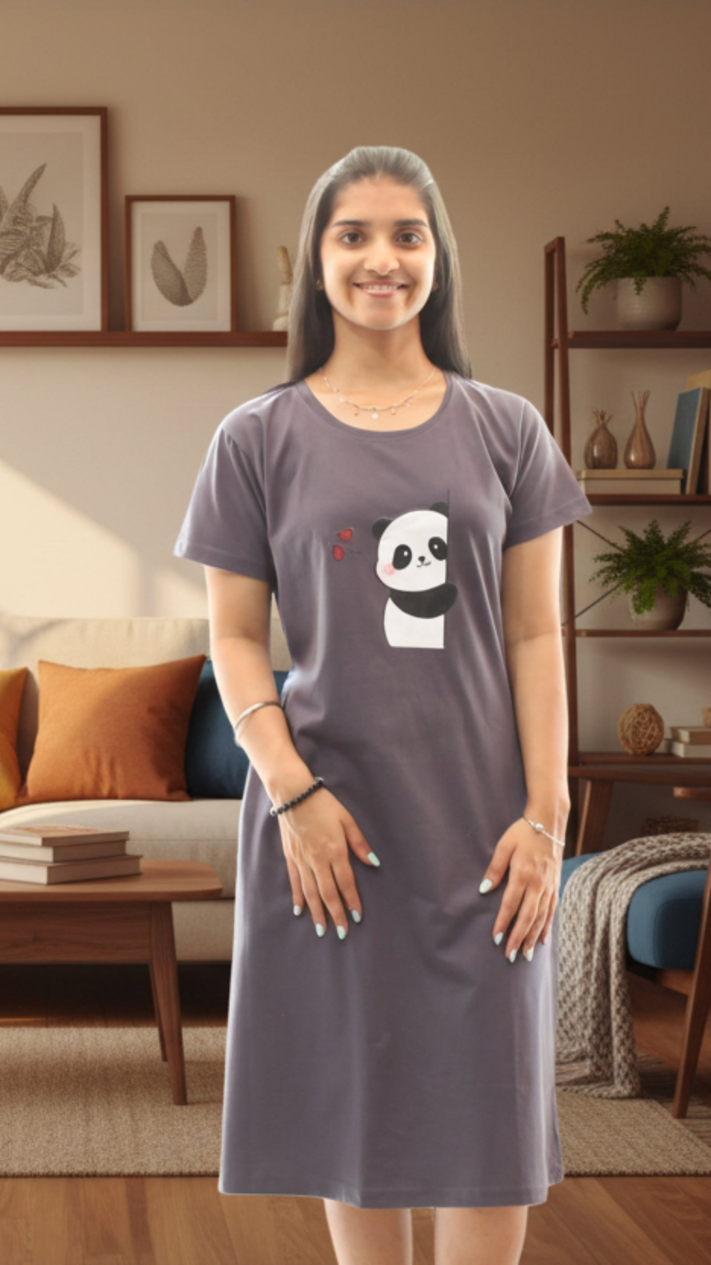 Woman wearing a gray t-shirt dress with a panda design in a living room.