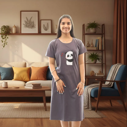 Woman wearing a grey short nighty with a panda design in a living room.
