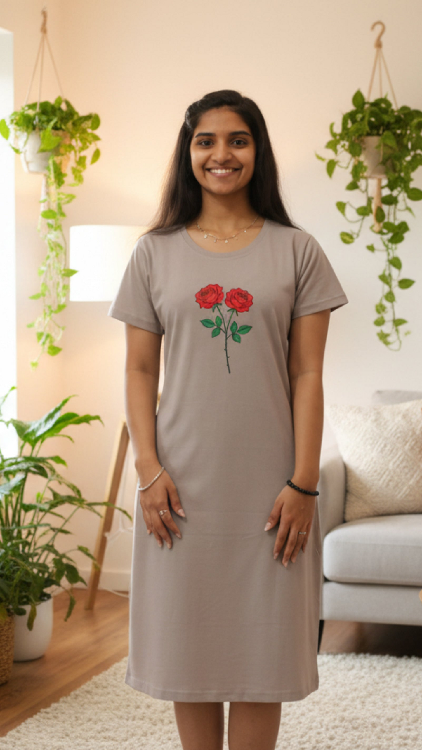 Woman wearing a gray dress with red floral design in a home setting