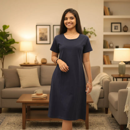 Woman in a navy blue knee length t shirt dress standing in a living room