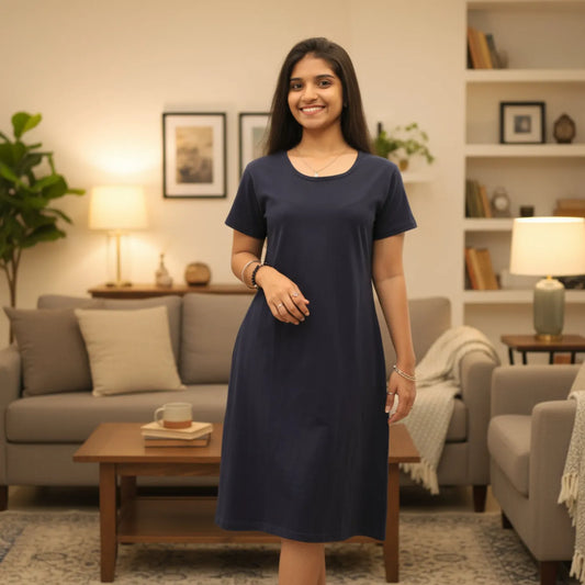 Woman in a navy blue knee length t shirt dress standing in a living room