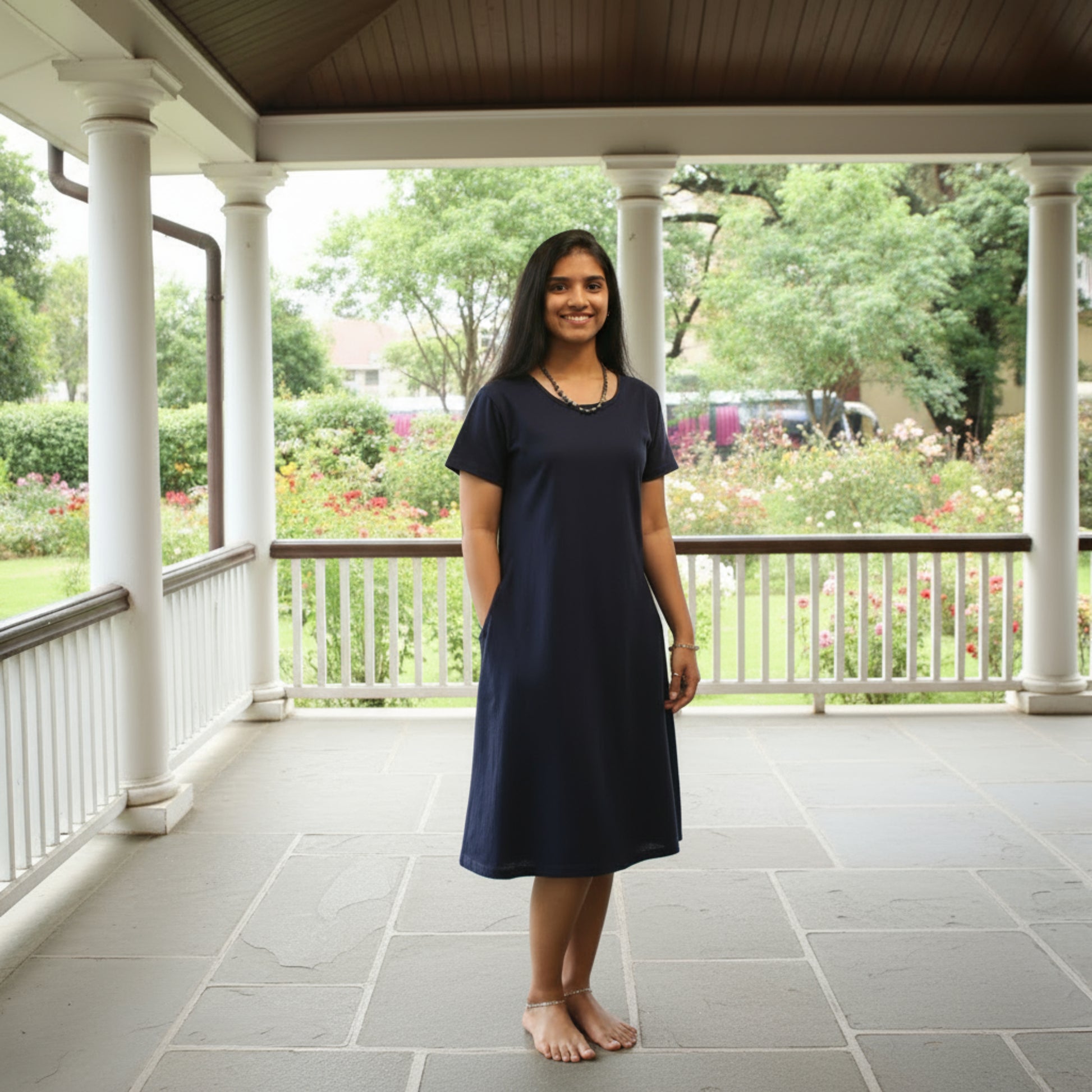 women wearing solid navy color t shirt dress with length upto the knee , putting hands in pocket
