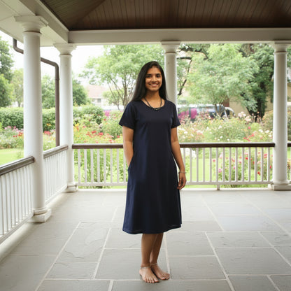 women wearing solid navy color t shirt dress with length upto the knee , putting hands in pocket