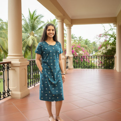 women wearing teal color cotton short nighty with pocket, it has print design all over 
