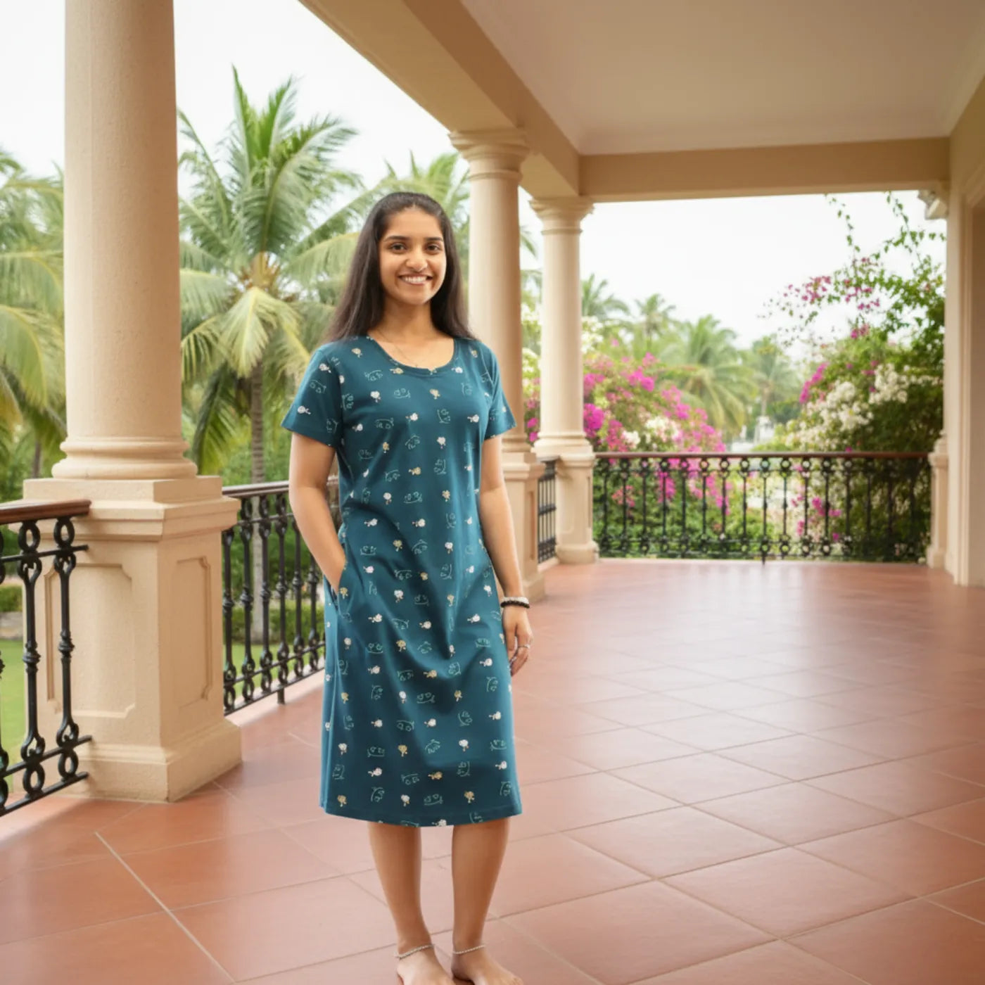 women wearing teal color cotton short nighty with pocket, it has print design all over 