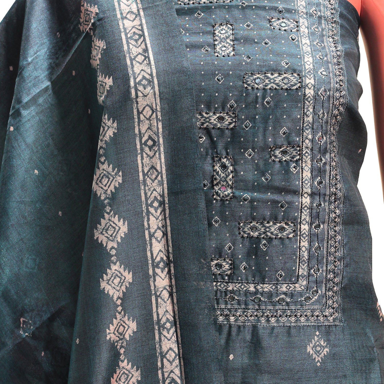 close up view of dress material with mirror and beaded work on the yoke